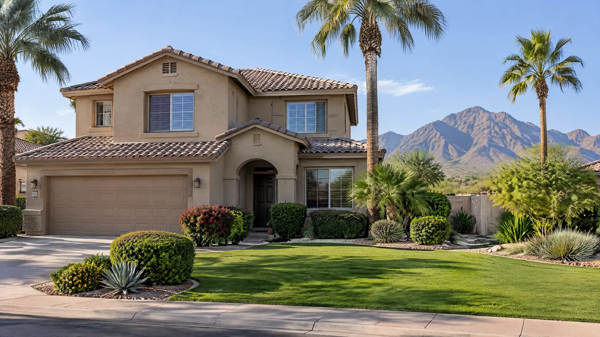 Two-story stucco home in south Tempe with a manicured front yard, palm trees, shrubs and a view of South Mountain